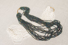 Load image into Gallery viewer, Zwei glamouröse Perlenketten mit vielen Strängen Mokolo liegend in Weiss und Schwarz
